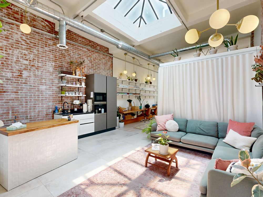 Calming interior of Erin Kumpf Acupuncture & Herbs in Jersey City, featuring exposed brick, a treatment room, and a cozy lounge seating area