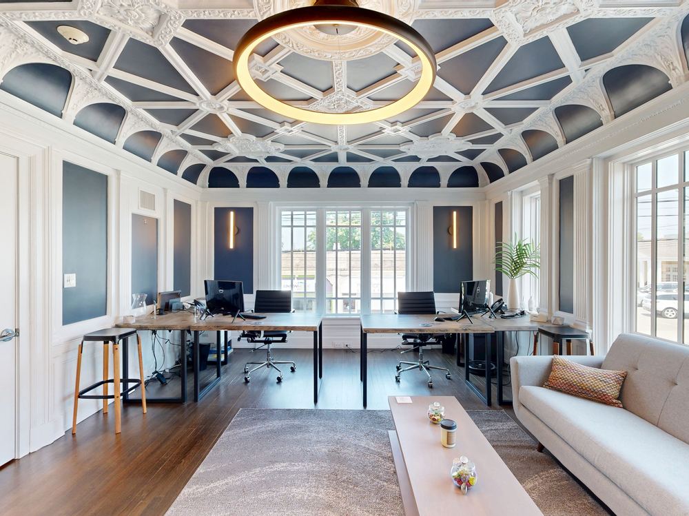 Van Der Wende & Benavente Real Estate Team's office with ornate coffered ceiling, workstations, and a seating area in Caldwell, New Jersey